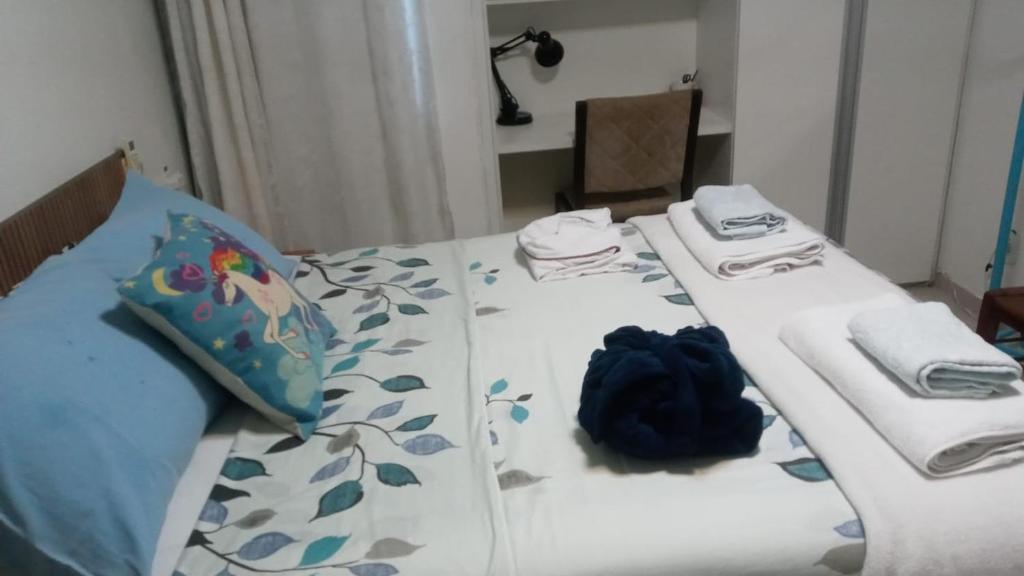 a bed with a blue bag sitting on top of it at QUARTO TRIPLO - PERTO DO CENTRO DE CONVENÇÕES-FENEARTE-CONFORTO e PRIVACIDADE- RECIFE-Pe in Recife