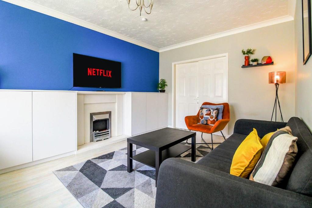 a living room with a couch and a tv at Spacious 4 Bedroom Home in Milton Keynes with Free Off Street Parking by HP Accommodation in Milton Keynes