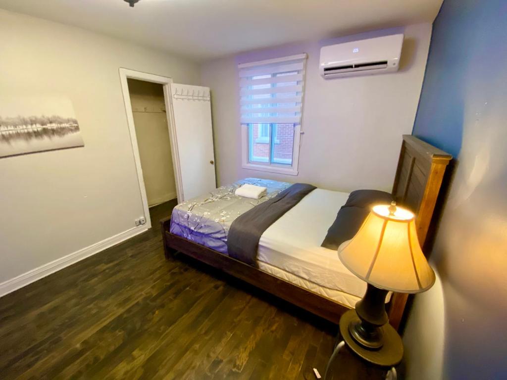 a small bedroom with a bed and a lamp at MontREAL HOMES - Affordable Rooms, Smart TV, Shared Kitchen in Montréal