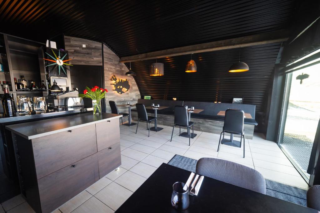 un restaurante con un bar con mesas y sillas en Dalahyttur, en Hlíð í Hörðudal