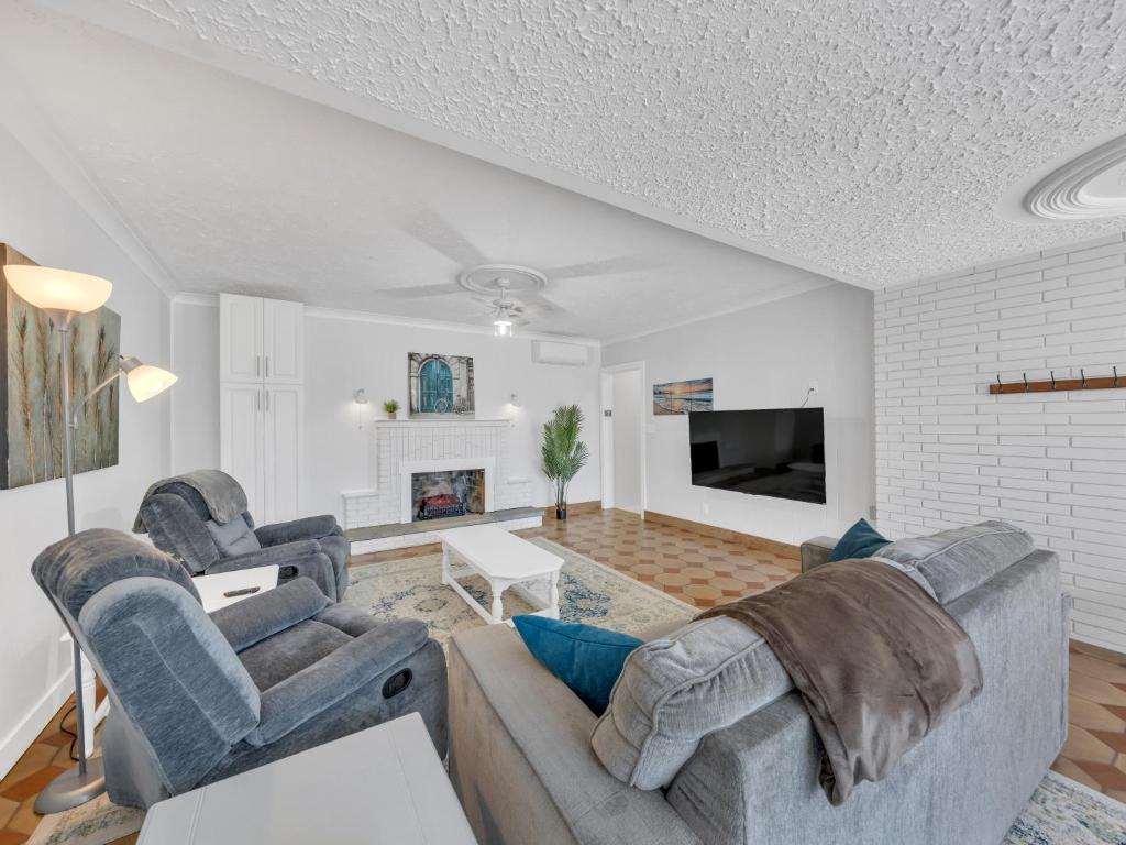 uma sala de estar com dois sofás e uma televisão em Parkside Flat - Seacliff Beach Suites em Leamington