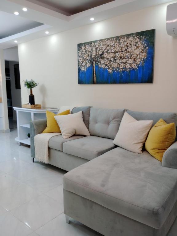 a living room with a couch and a painting on the wall at Apartamento céntrico en Santiago in Santiago de los Caballeros
