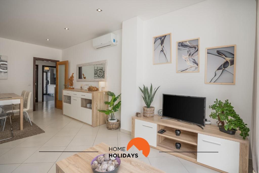 een woonkamer met een flatscreen-tv op een kast bij #194 Dream Flat by Home Holidays in Vale de Pedras