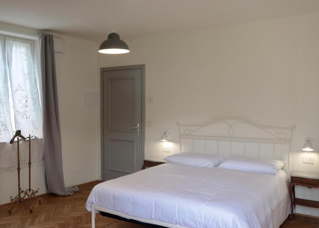 een slaapkamer met een wit bed en een raam bij Casa Viola Bed and Breakfast in Calice Ligure