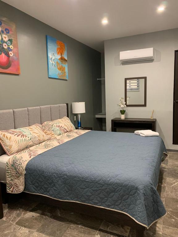 a bedroom with a bed with a blue comforter at Hotel Residencial Edzná Calle 10 in Campeche
