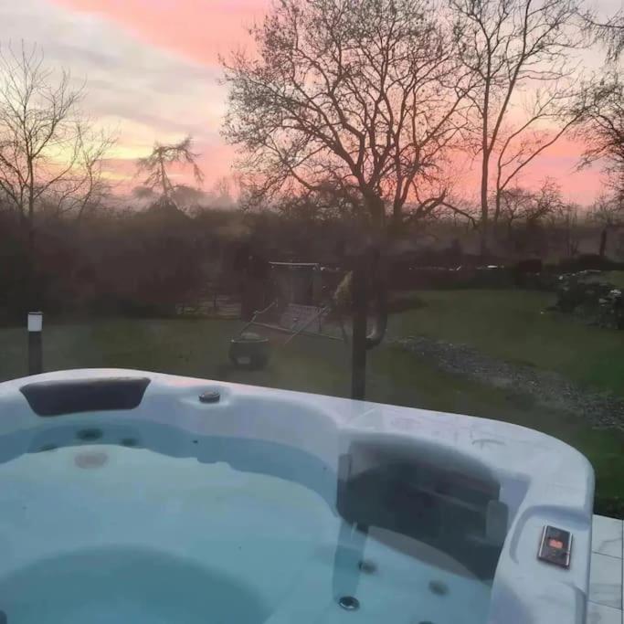 a bath tub with a view of a yard at Mill View Cottage at Pheasant Lane in Ráistín
