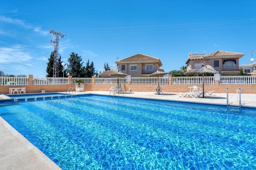 a swimming pool in front of a house at Rincón de sol y relax in Torrevieja