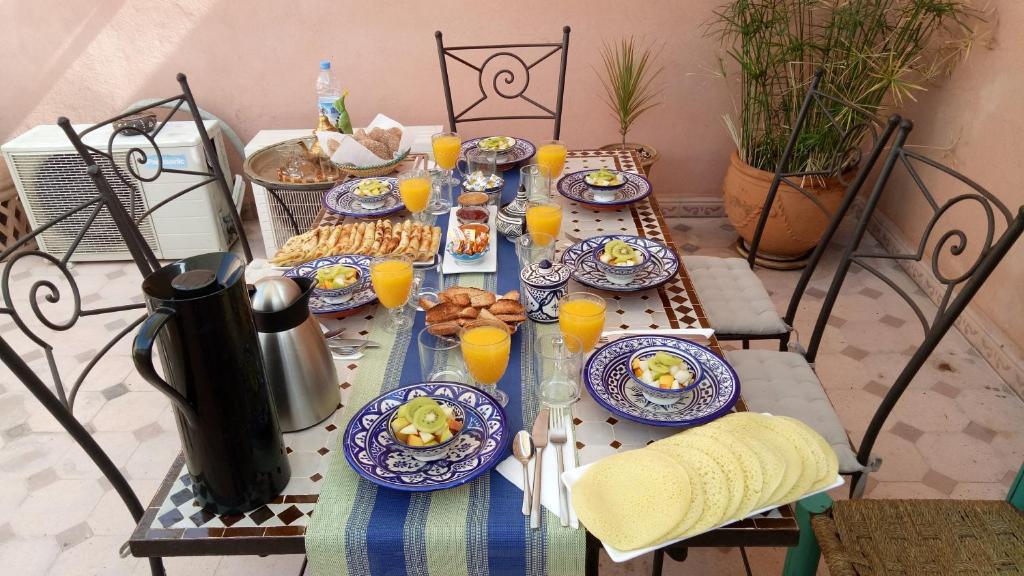 - une table avec des plaques de cuisson et du jus d'orange dans l'établissement Riad Majdoulina chez JIJI, à Marrakech