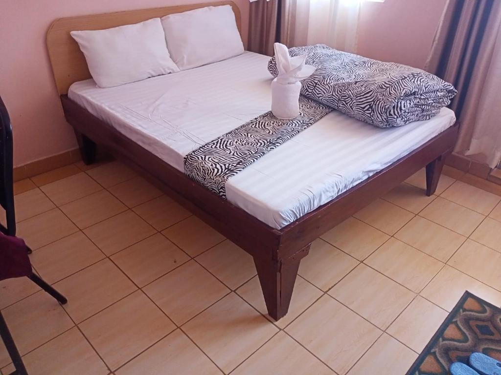 una pequeña cama con un conejo sentado encima de ella en Hotel Illusions, en Kakamega