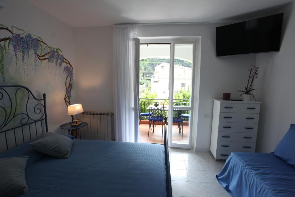 a bedroom with a bed and a view of a balcony at Jungle Rooms in Cetara