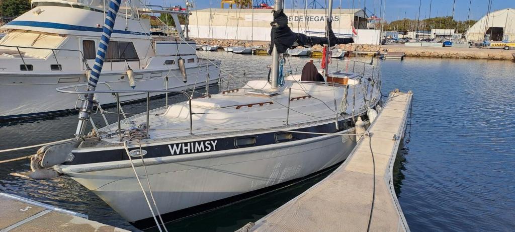 un barco blanco atracado en un muelle en el agua en Velero Valencia Whimsy en Valencia