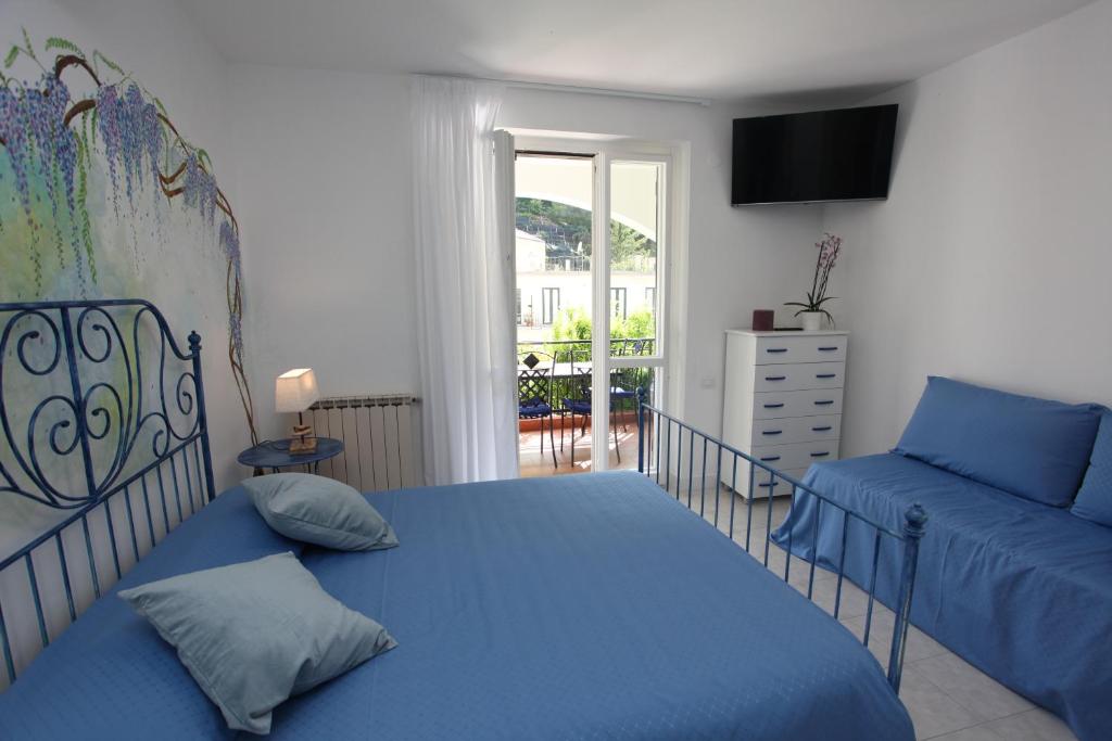 a bedroom with a blue bed and a couch at Jungle Rooms in Cetara