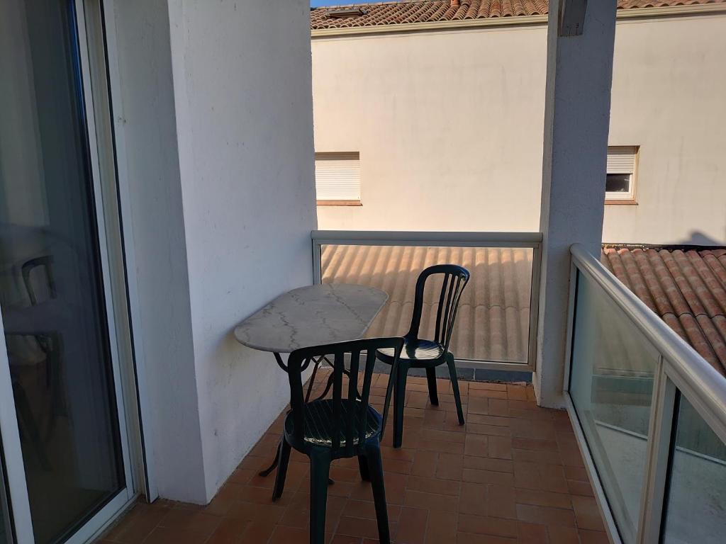 a small table and two chairs on a balcony at Chambre d&#39;hôtes in Valras-Plage