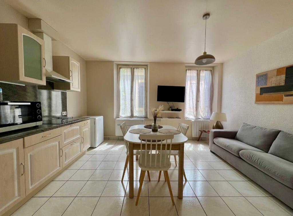 a kitchen and living room with a couch and a table at PETIT CAPUCIN in Carcassonne