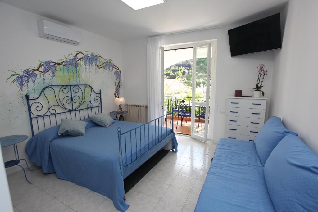 a bedroom with a blue bed and a couch at Jungle Rooms in Cetara