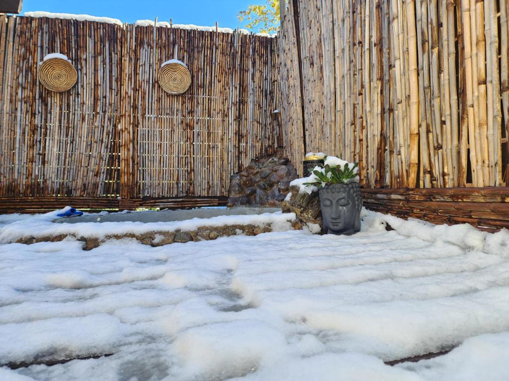 une clôture avec un vase dans la neige dans l'établissement Cabaña Jacuzzi Exterior Privado, à San José de Maipo