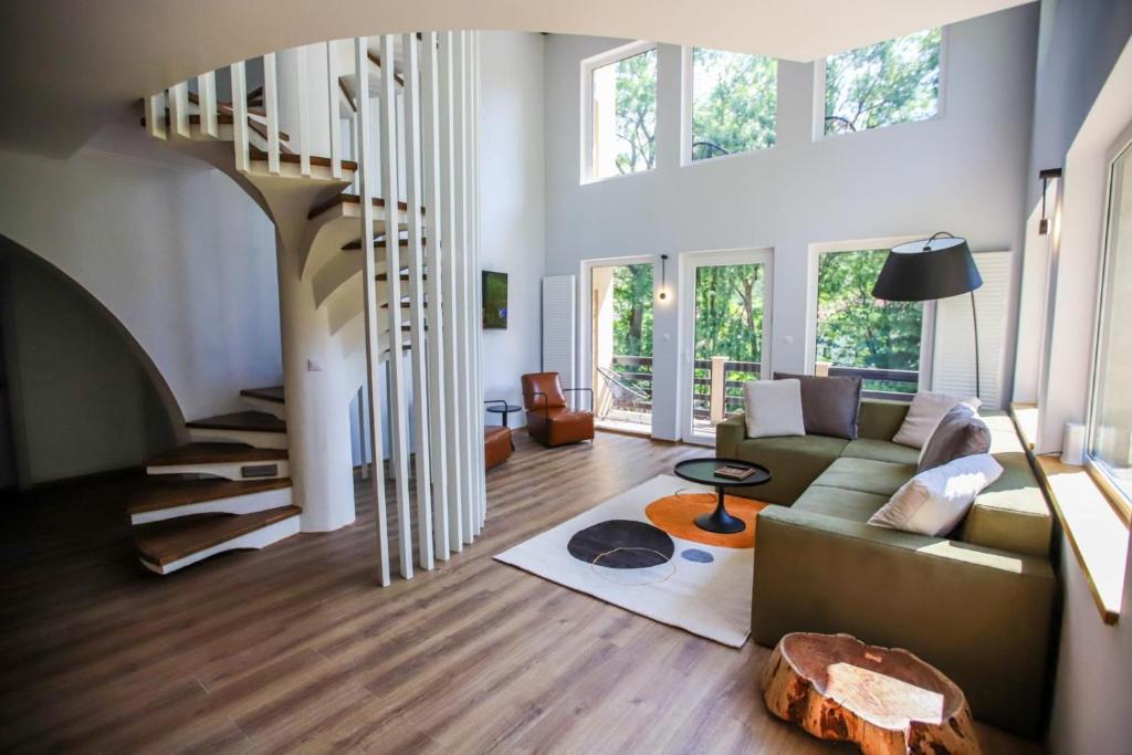 a living room with a couch and a spiral staircase at Kassa in Bran