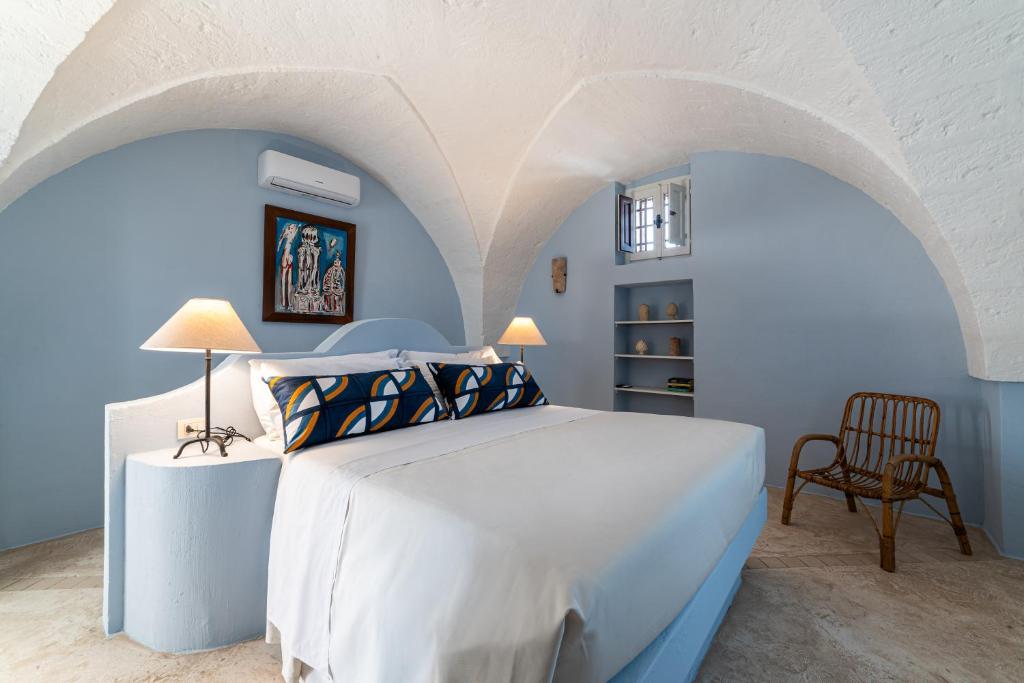 a bedroom with a white bed and a chair at Masseria Borgo San Marco in Fasano