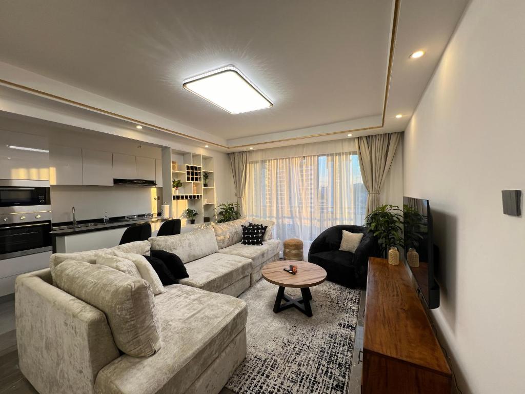 sala de estar con sofá y mesa en RUYER LUXURY 1BR kileleshwa, en Nairobi