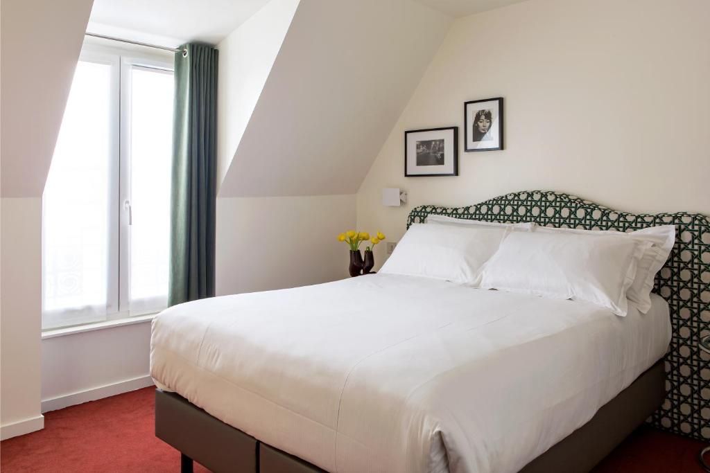 パリにあるHôtel Dalilaのベッドルーム(大きな白いベッド1台、窓付)