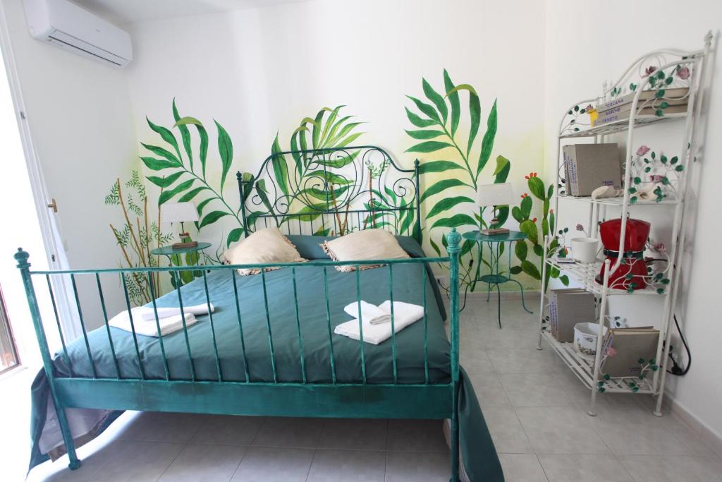 a bed in a room with plants on the wall at Jungle Rooms in Cetara
