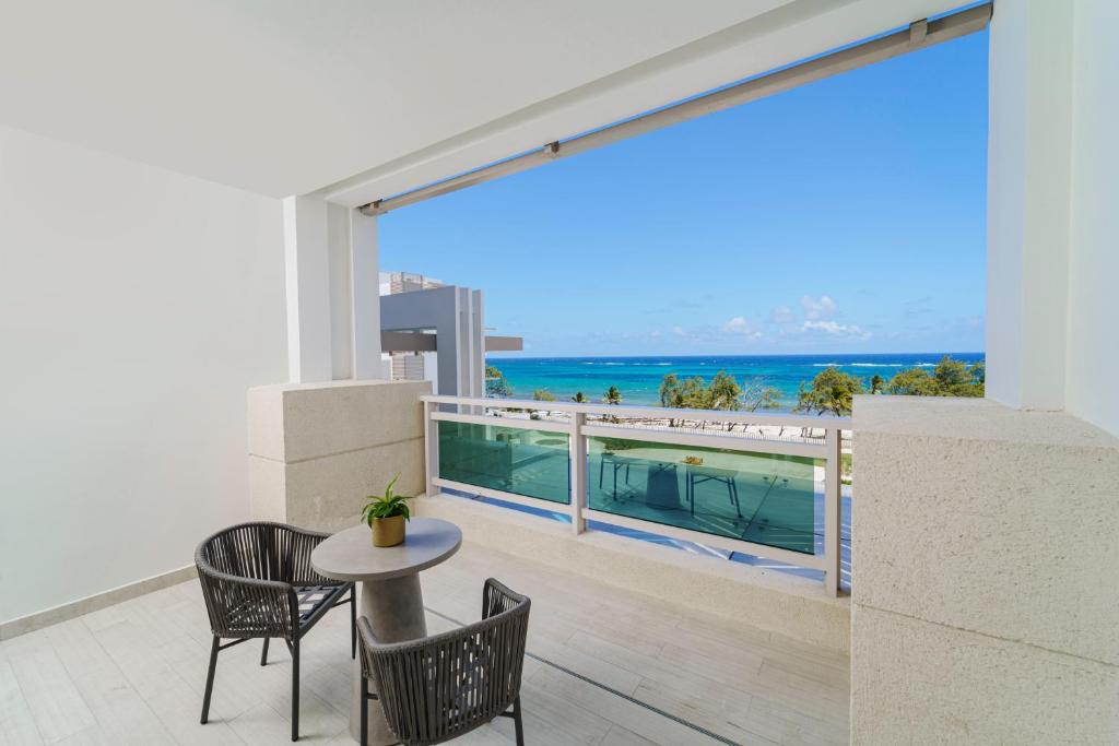 a balcony with a table and chairs and a view of the ocean at Wyndham Grand Barbados Sam Lords Castle All Inclusive Resort in Saint Philip