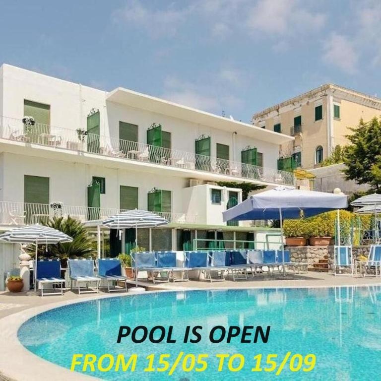 Una piscina está abierta desde hasta frente a un hotel. en Casa Colomba, en Anacapri
