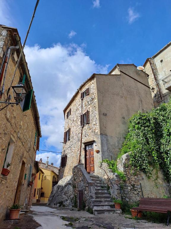 an old stone building with a wooden door and stairs at la casina di asia in Semproniano