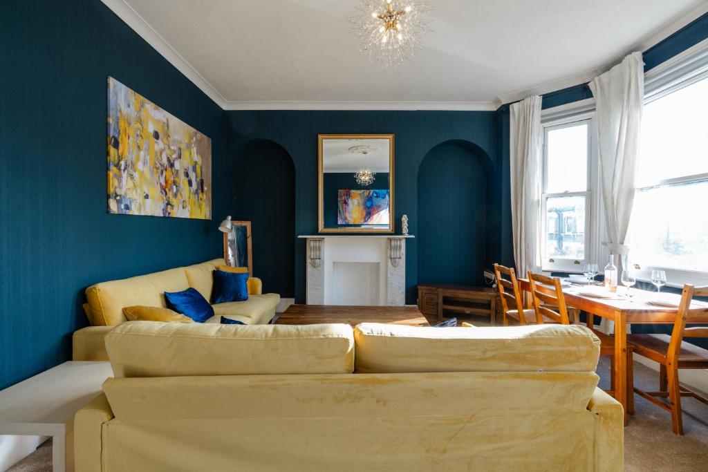 uma sala de estar com 2 sofás e uma sala de jantar em 4 bedroom Stunning Flat Near Westfield & Trains em Londres