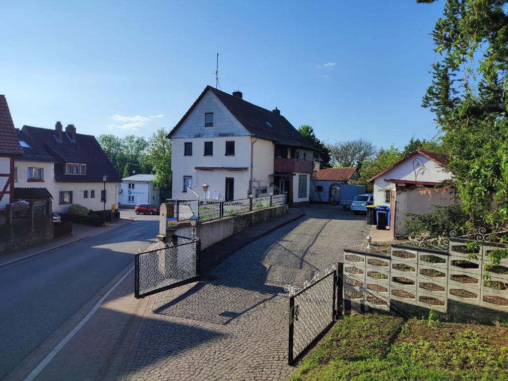 a street with a white house and a fence at Ferienhaus Richard in Eschwege