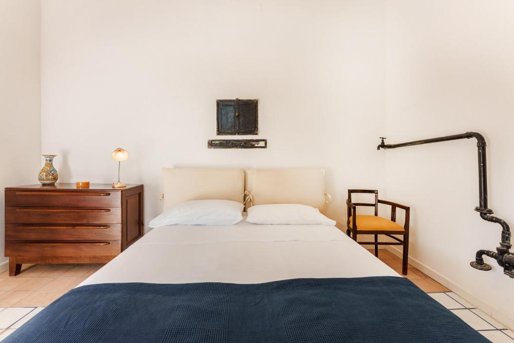 a bedroom with a bed and a wooden dresser at Villetta con giardino nel centro storico in Procida