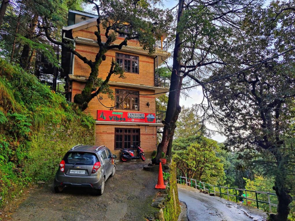 samochód zaparkowany przed budynkiem na polnej drodze w obiekcie Jakhu Vibes w mieście Shimla