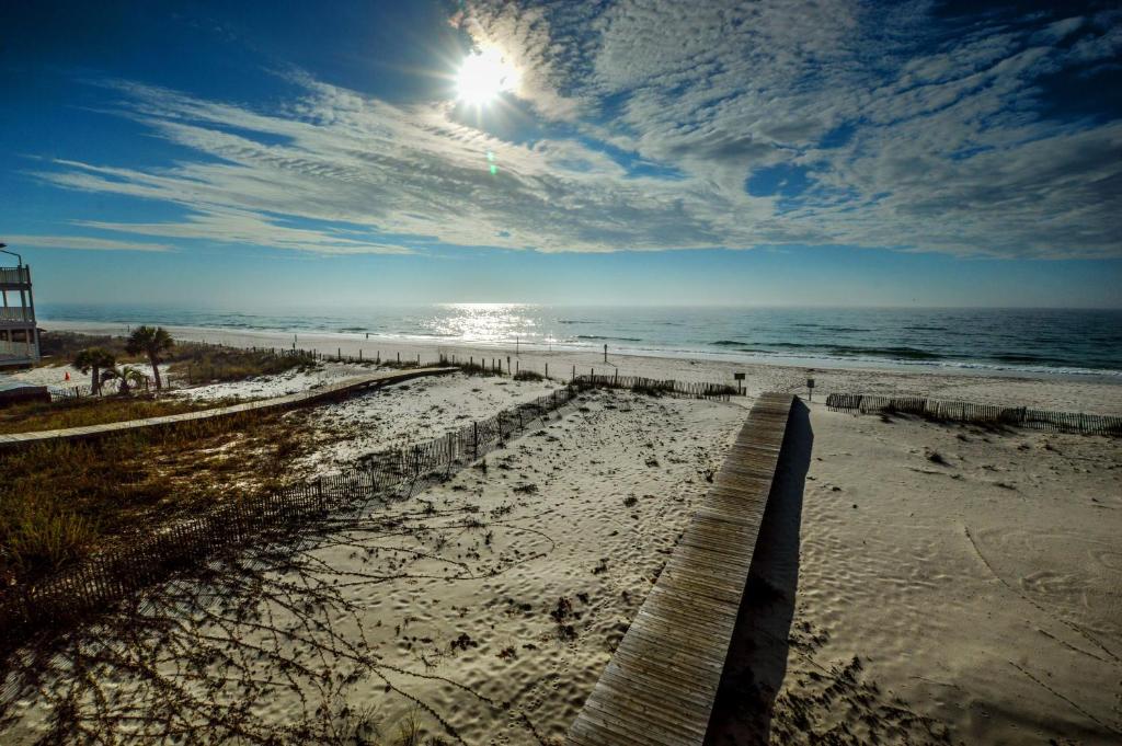 a view of a beach with the sun and the ocean at The Beach is Only Steps Away (F2) BEACHFRONT - Sleeps 8 in Gulf Shores