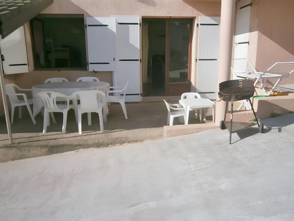 een patio met een tafel en stoelen en een grill bij Appartement de 2 chambres a Mimizan a 100 m de la plage avec terrasse amenagee in Mimizan