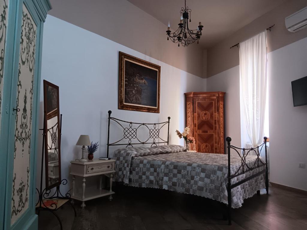 1 dormitorio con cama, mesa y lámpara de araña en B&B Prima Classe, en Battipaglia