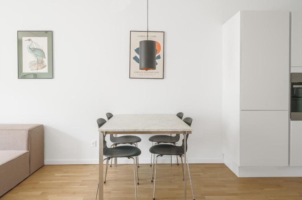a kitchen with a table and four chairs at Modern 2-bed apartment in Ørestaden in Copenhagen