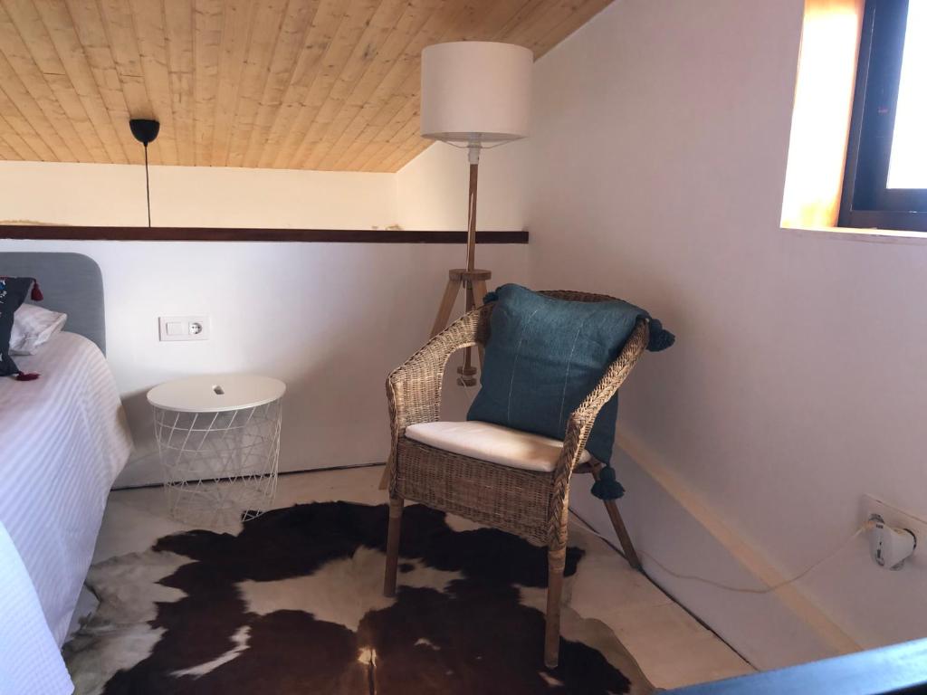 ein Korbstuhl in einer Ecke eines Schlafzimmers in der Unterkunft Villa Calderón Hondo in Lajares