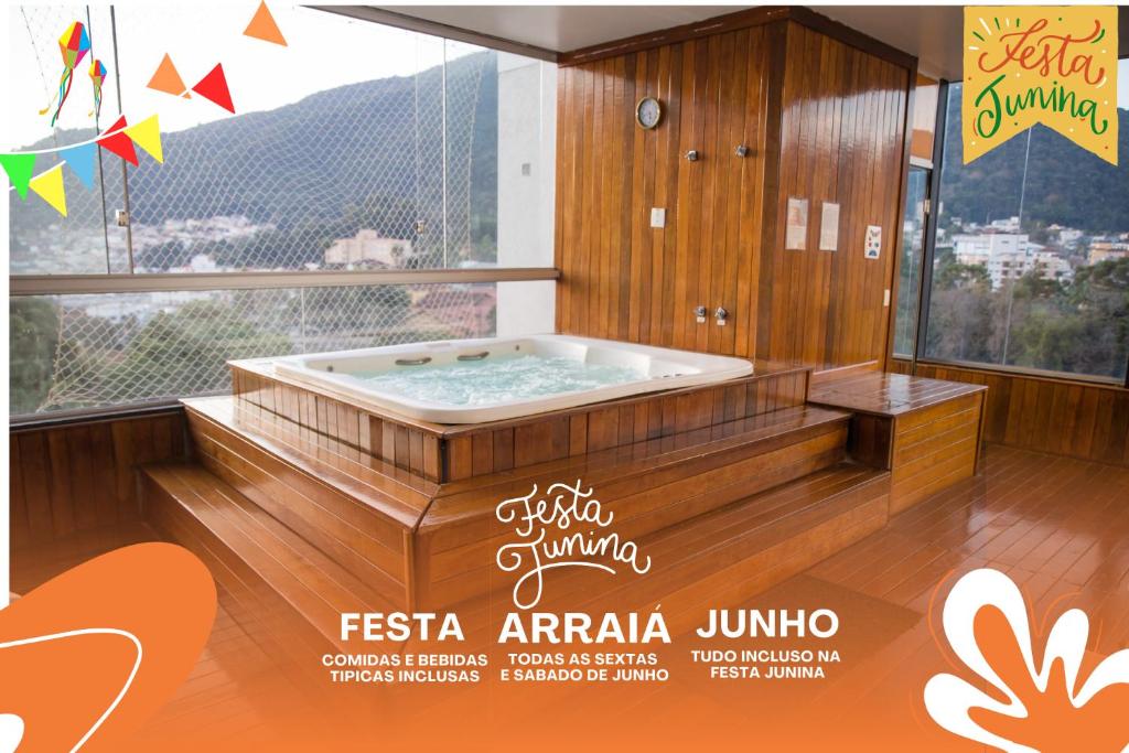 Minas Garden Hotel في بوكوس دي كالداس: ملصق بحوض استحمام ساخن في غرفة مع نافذة