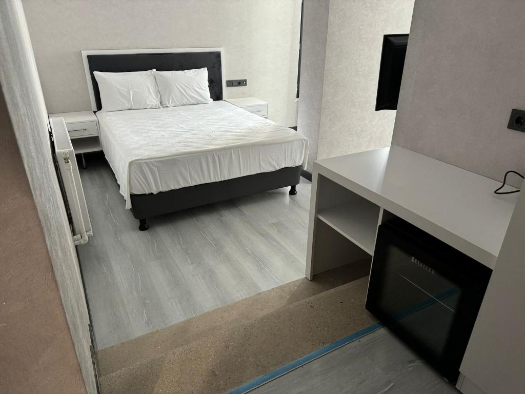 ein kleines Schlafzimmer mit einem Bett und einem Schreibtisch in der Unterkunft Beyoğlu Palas Otel in Diyarbakır