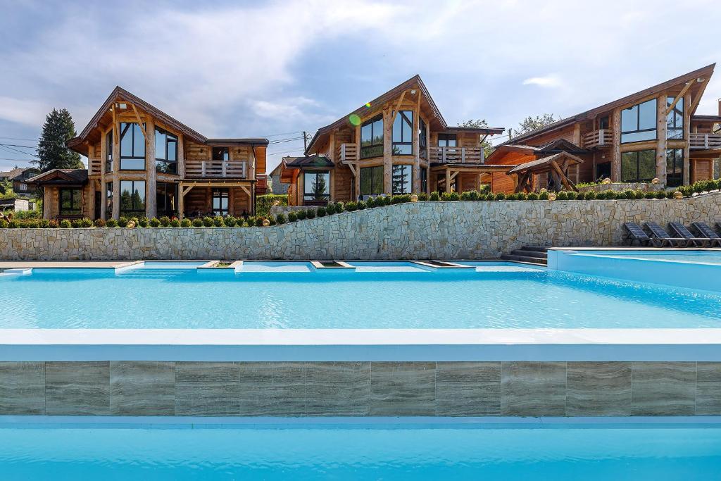 a large house with a swimming pool in front of it at Adel Resort in Plav'ya