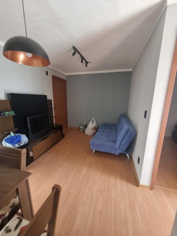 a living room with a blue couch and a tv at Apartamento araraquara in Araraquara