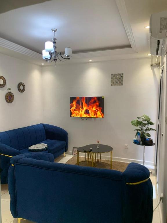 Gokus Home في دوالا: غرفة معيشة مع أريكة زرقاء ومدفأة
