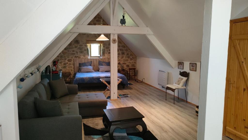 a living room with a bed and a couch in a attic at La Cifouille in La Fouillade