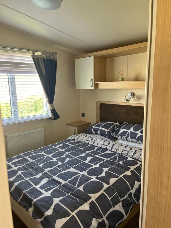 1 dormitorio con 1 cama con edredón azul y blanco en 21 Riverview, Allhallows, en Rochester
