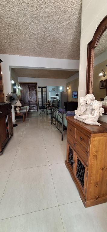 a large living room with a mirror and a table at Studio Flat near Sea in Xlendi