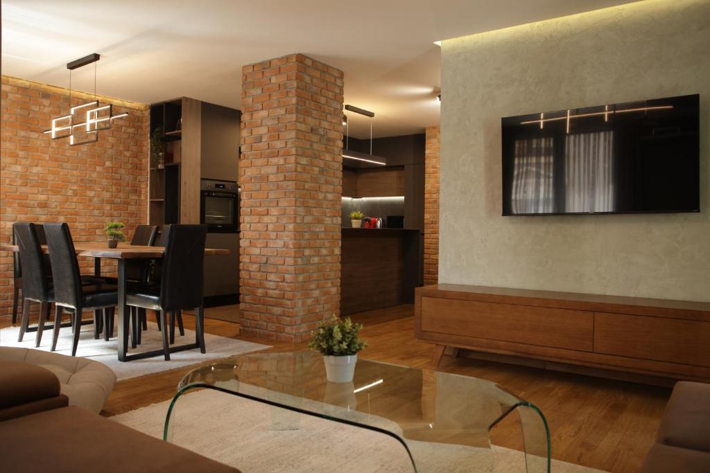 a living room with a table and a brick wall at SkopjeLUX Apartments in Skopje