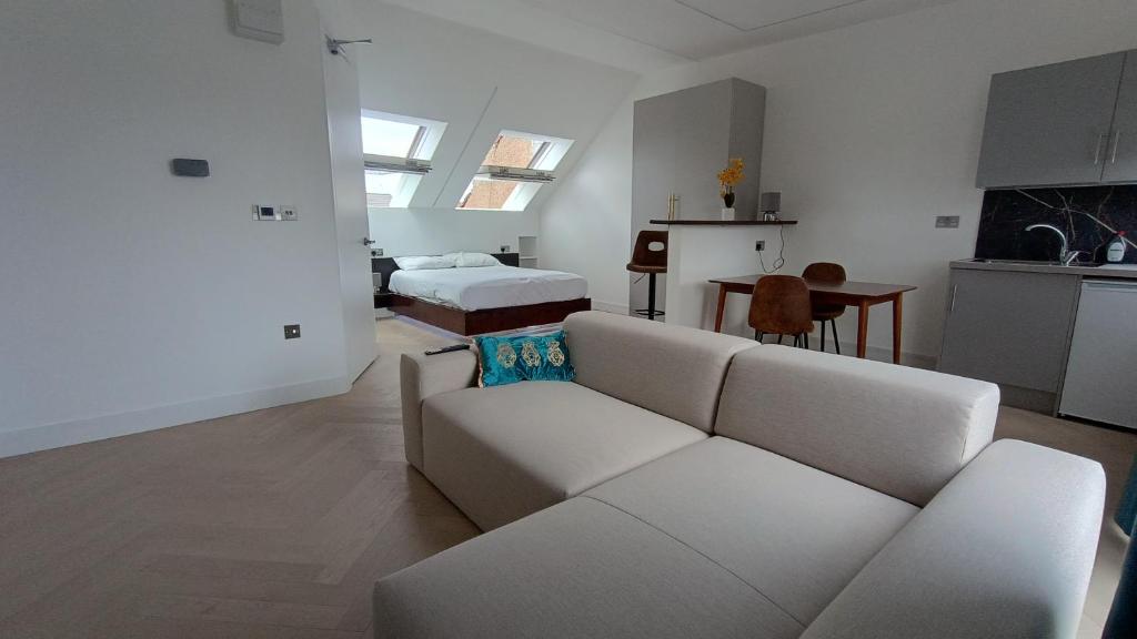 a white living room with a couch and a bed at Luxurious London Studios in Harrow