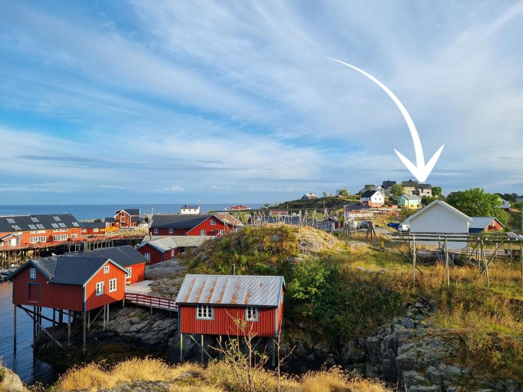 a group of houses on a hill next to the water at Villa The high end of Lofoten in Moskenes