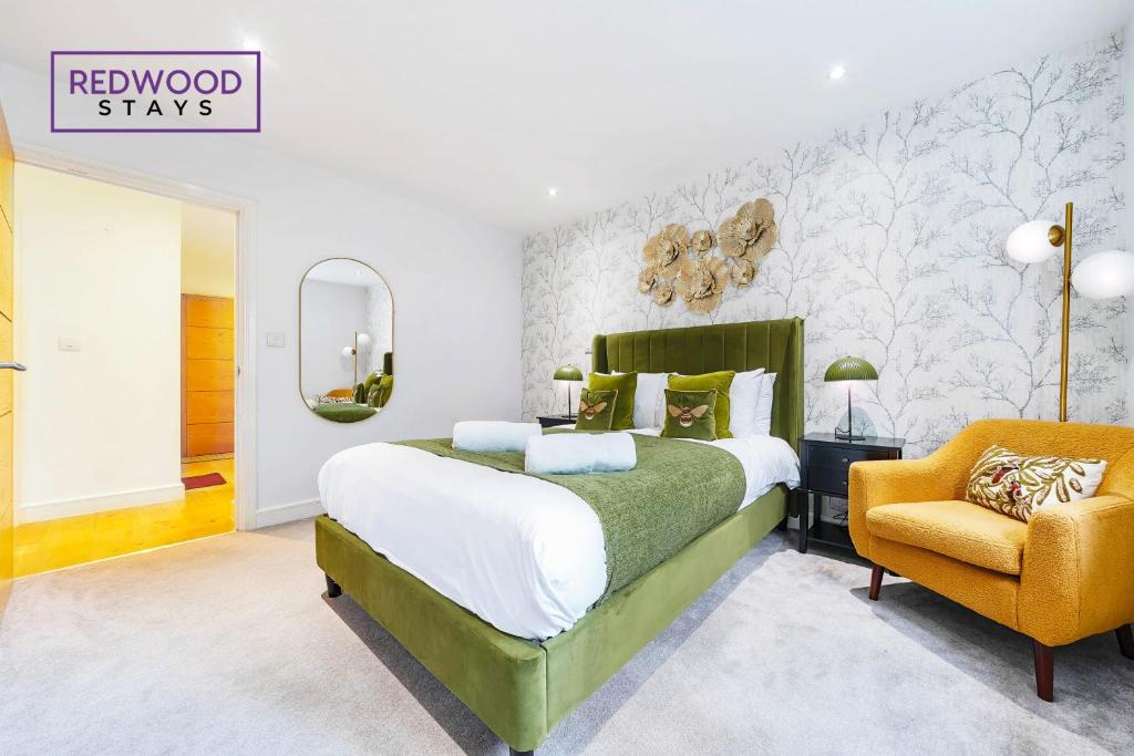 Un dormitorio con una cama verde y una silla amarilla en 2 Bedroom 2 Bathroom Apt in Camberley Free WiFi By REDWOOD STAYS en Camberley