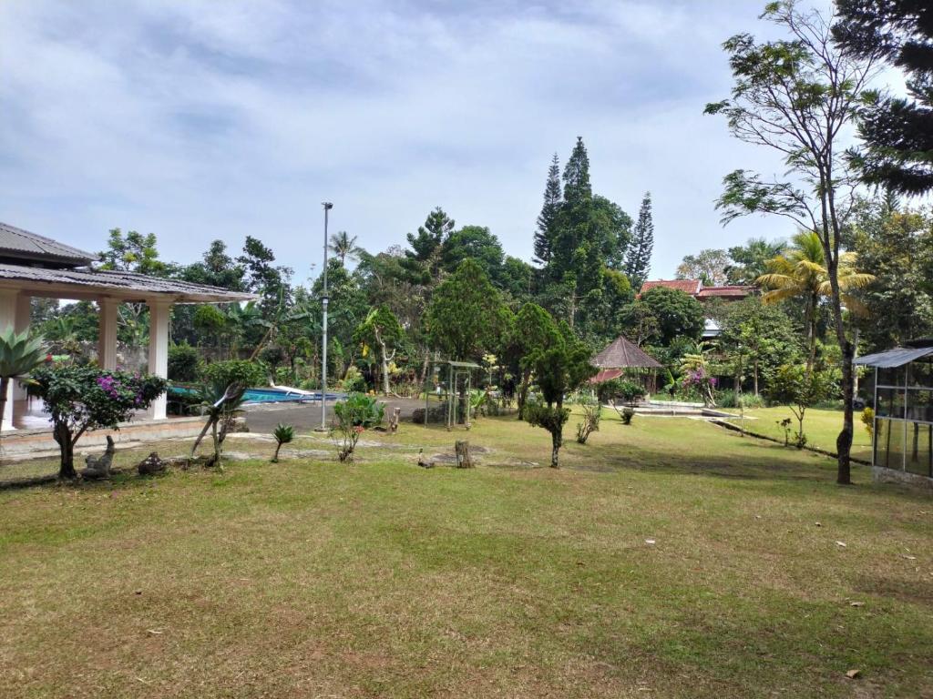 a park in front of a building with trees at Villa Ledenfi in Cisarua